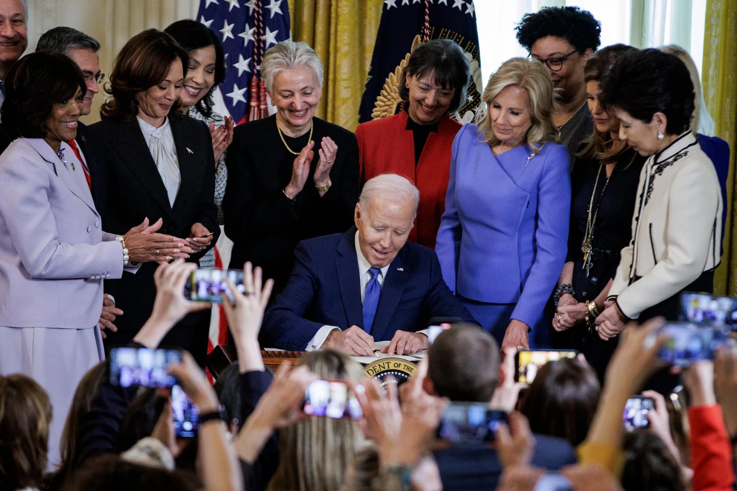 US President, Joe Biden, signs an Executive Order surrounded by senior female leaders and decision-makers