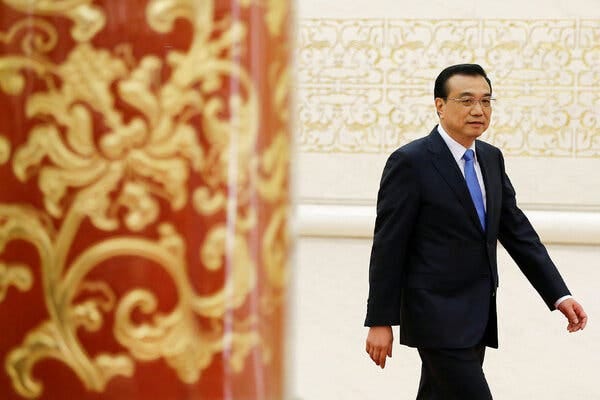 China’s former premier, Li Keqiang, wearing a dark blue suit, white shirt and light blue tie, walking to a news conference in 2017.