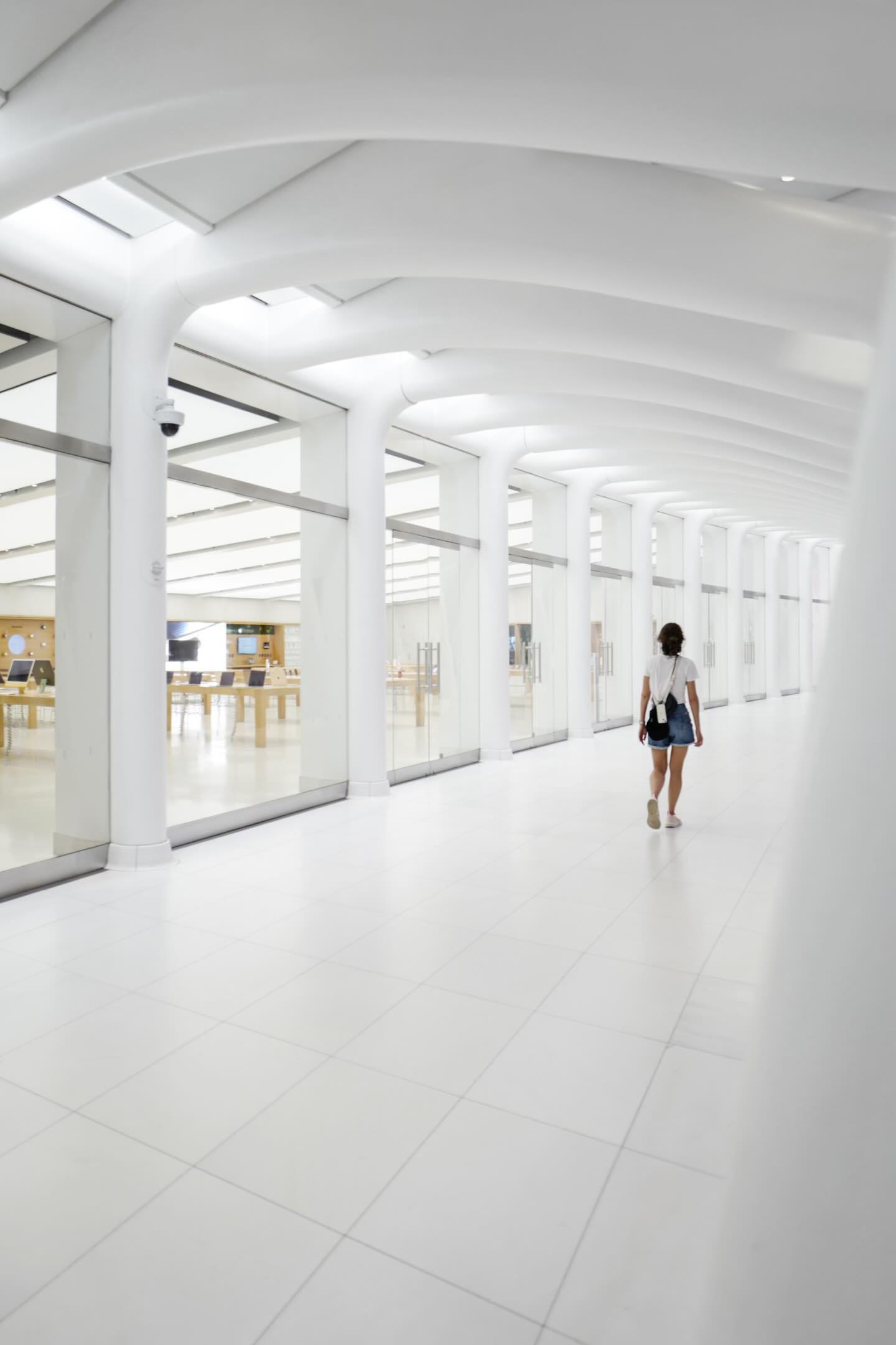 A person walks down an empty mall corridor outside the upper level of Apple World Trade Center.