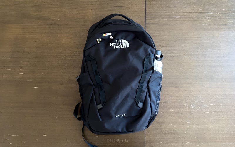 The North Face Vault BackPack. Black color on brown table.