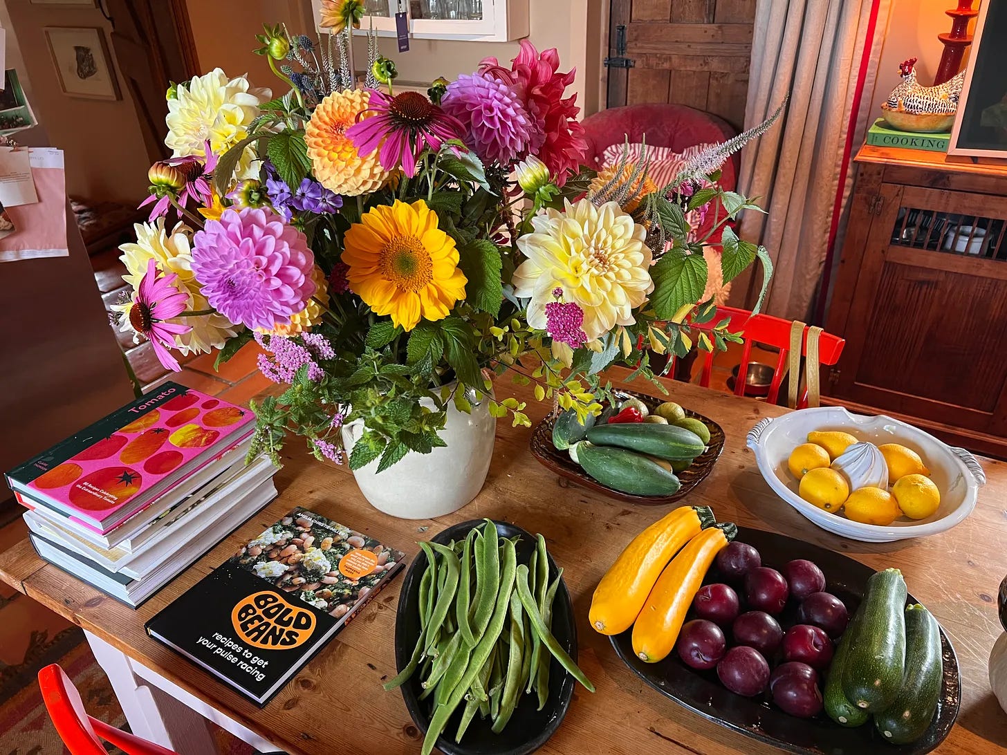 colourful flowers and vegetables  and books on a wooden table