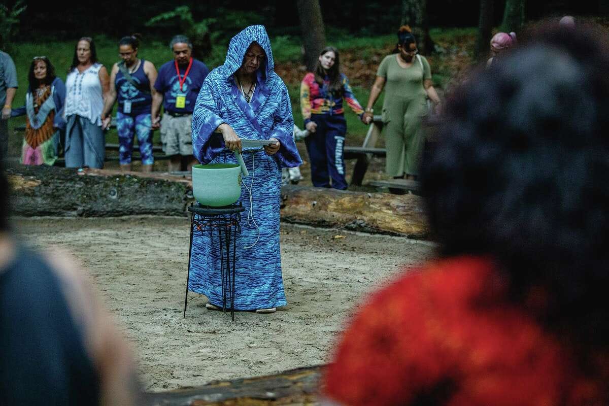 Mary Kimball presides over the fire ritual, which also features the element of water, represented by her blue robe.