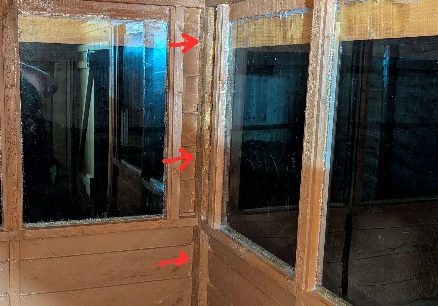 Annotated photo showing the corner joint of shed panels, highlighting a missing internal wooden framework where internal walls would typically attach.