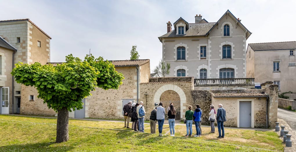 Groupe de personnes devant la maison de l'écrivain Julien Gracq à Saint-Florent-le-Vieil (France)