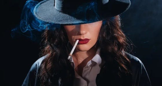 a woman smoking a cigarette while wearing a suit with a hat pulled down over her eyes, like a noir detective