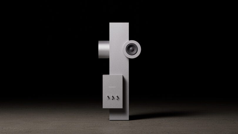 Minimalist silver geometric sculpture with a cylindrical speaker component on a dark background.