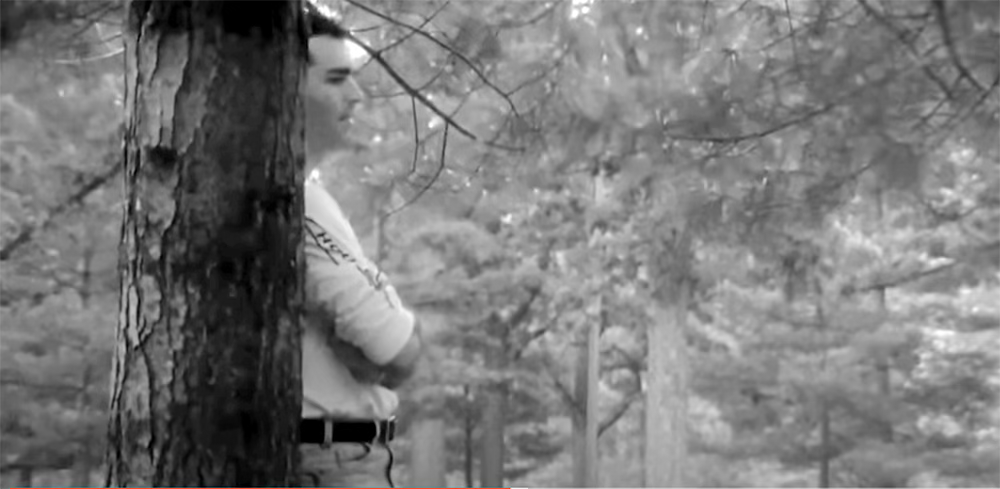 Christopher stands in a cemetery watching his sister visit their mother's grave