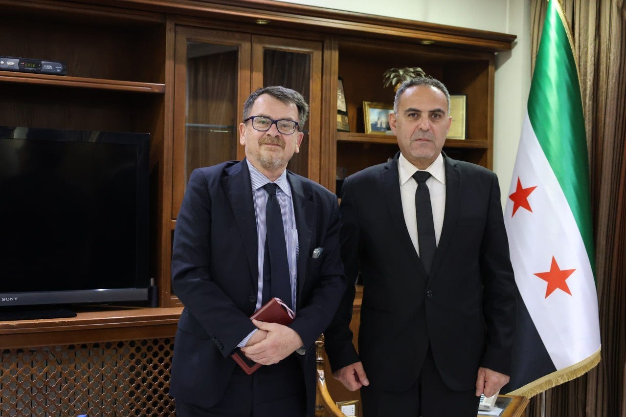 Two men in suits standing in front of a flag

AI-generated content may be incorrect.