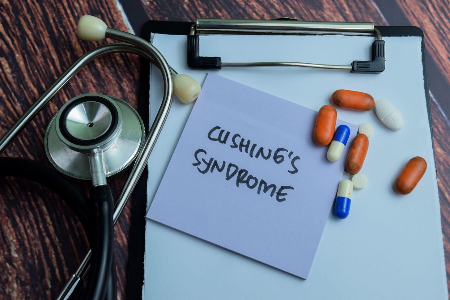 Concept of Cushing's Syndrome write on sticky notes with stethoscope isolated on Wooden Table.