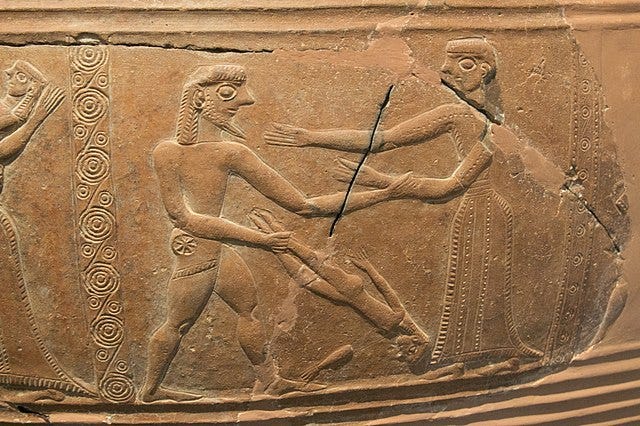 Photograph of a figured panel from a clay vase showing a warrior swinging an infant