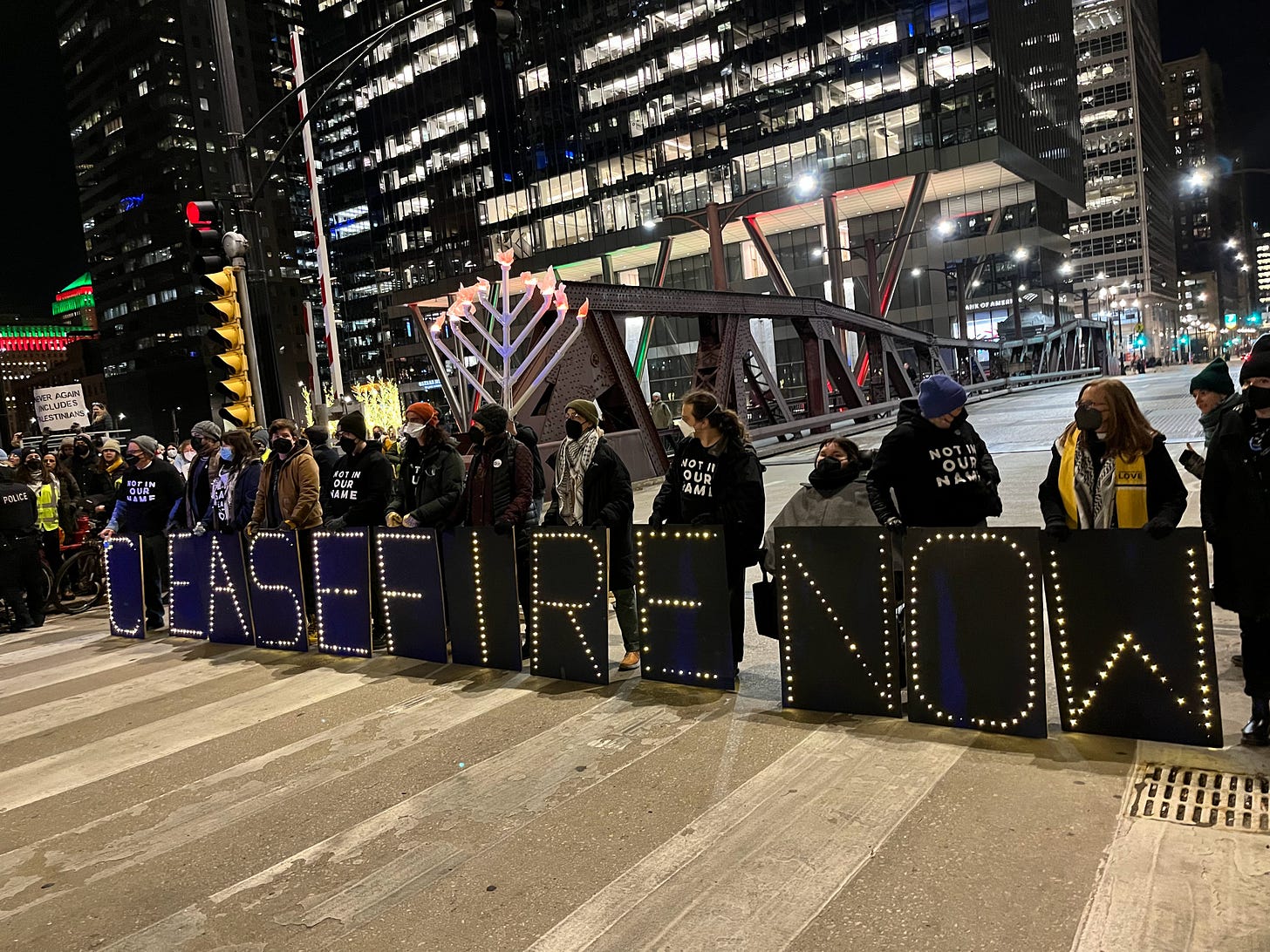 Protesters hold lighted letters that read CEASEFIRE NOW while blocking a bridge in downtown Chicago.