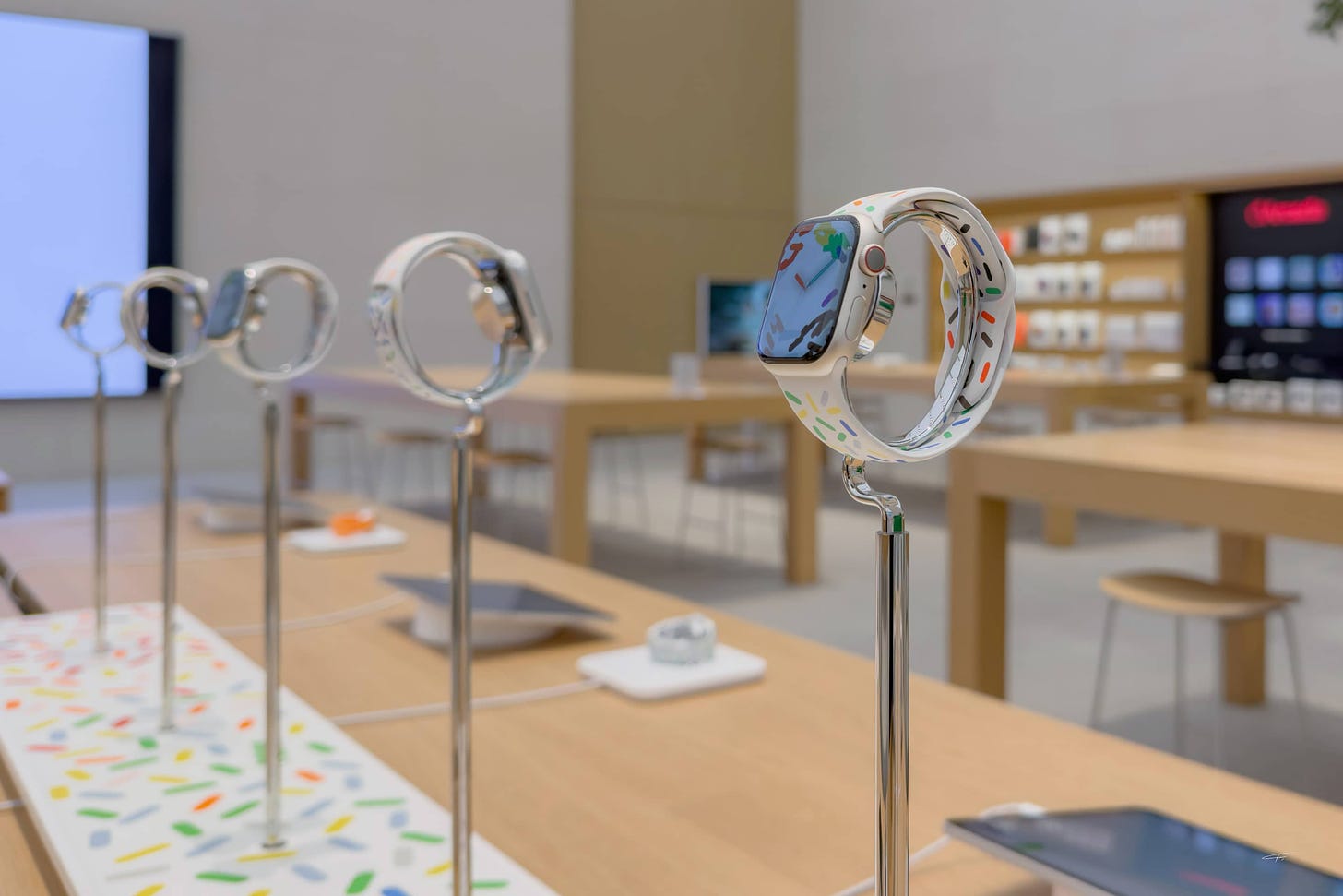 The Apple Watch Pride riser. A series of Apple Watches are mounted on polished pedestals.