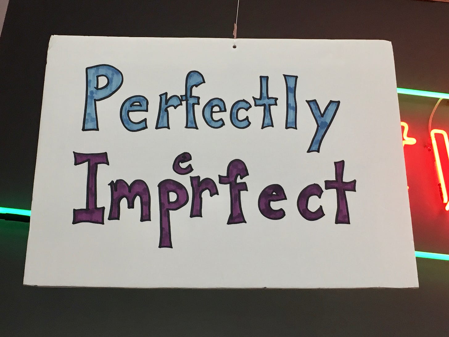 shop sign that says "perfectly imperfect" with the "e" of imperfect written as an afterthought, i.e. imperfectly