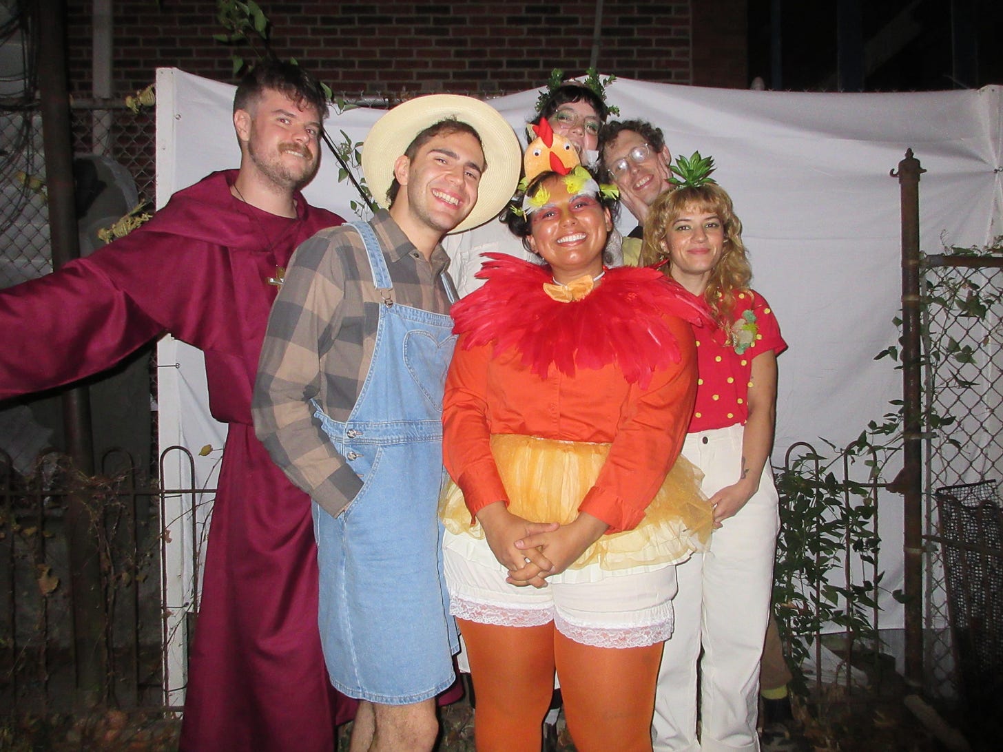 a group of friends dressed in halloween costumes: a priest, a farmer, a chicken, a moldy strawberry, a woodland fairy, and one un-costumed friend.