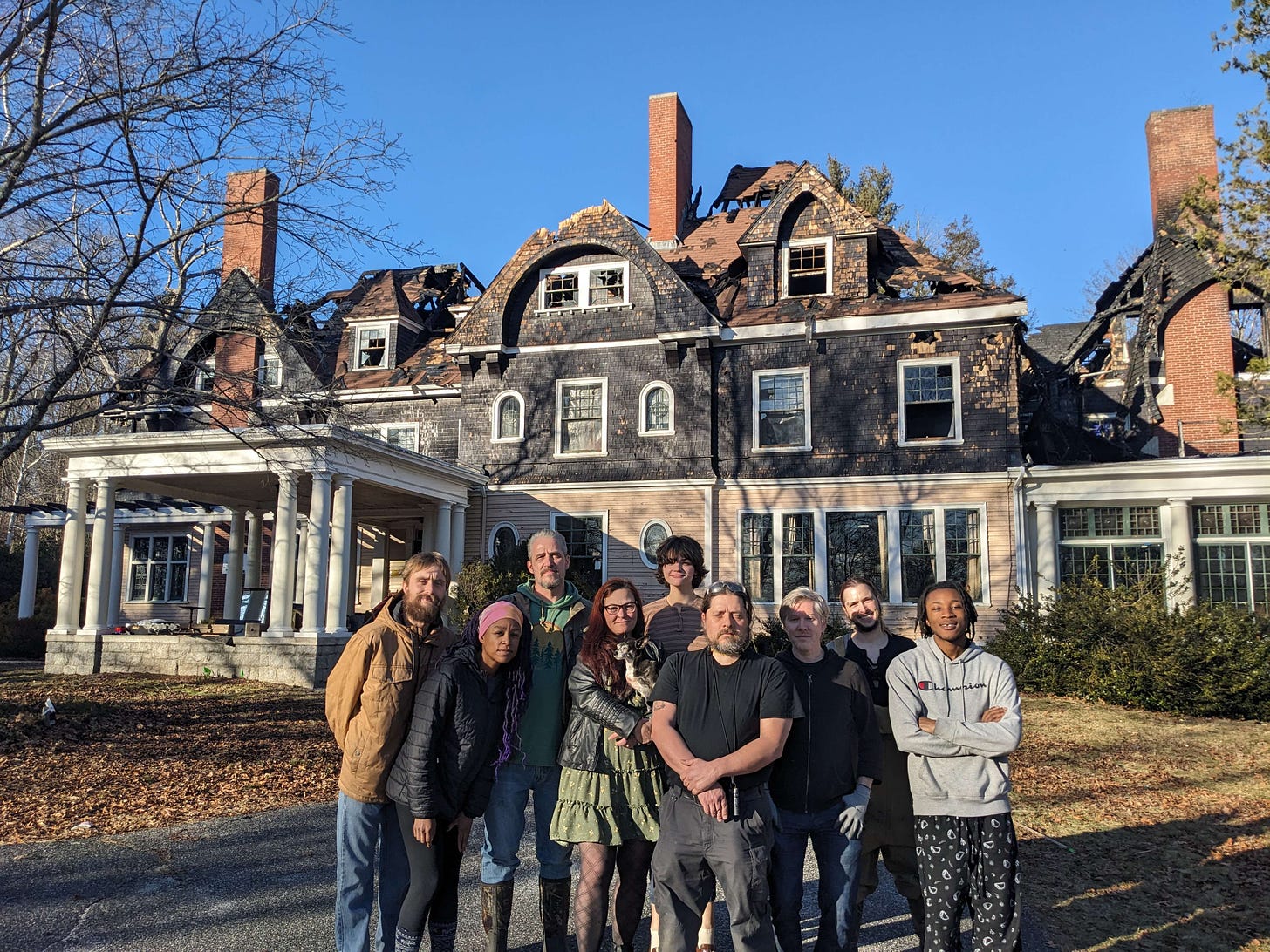 Some of the survivors from the Oakhurst Manor fire and fellow residents standing in front of the condemned manor building.