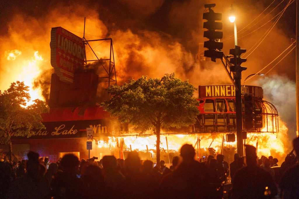 Protesters gather in front of a liquor store in flames near the Third Police Precinct on May 28, 2020 in Minneapolis, Minnesota, during a protest over the death of George Floyd