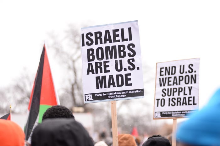 Pro-Palestinian protesters hold signs that say "Israeli bombs are US made" and "End US weapons supply to Israel." Pro-Palestinian protesters hold signs that say "Israeli bombs are US made" and "End US weapons supply to Israel."