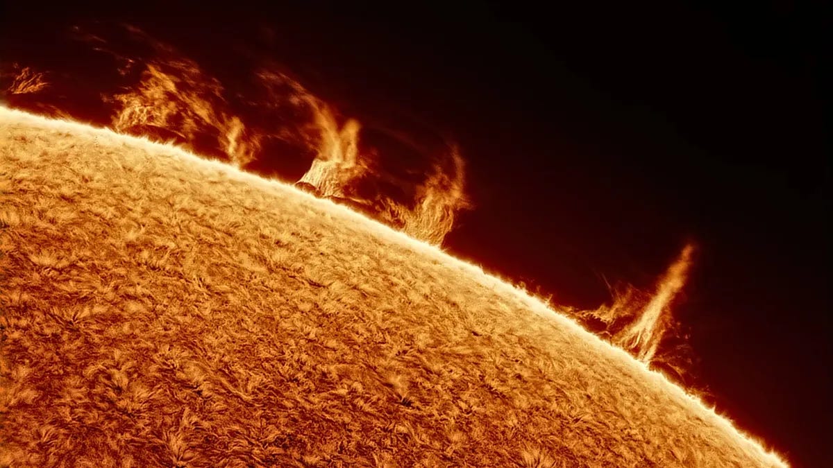  Solar prominences dance across the sun's limb in various shades of brilliant orange against the black of space. 