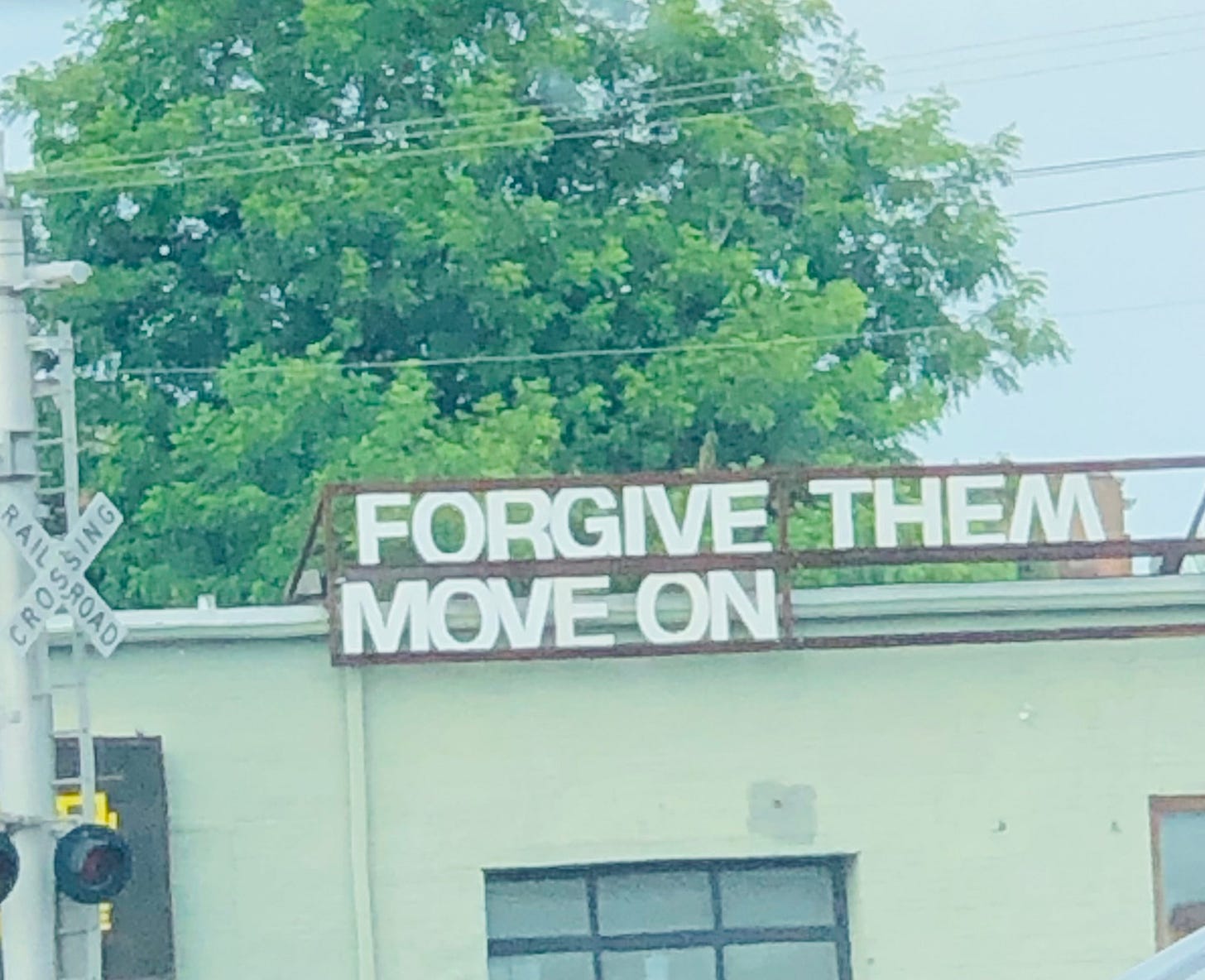 a photo of large letters on the side of a building that read FORGIVE THEM MOVE ON