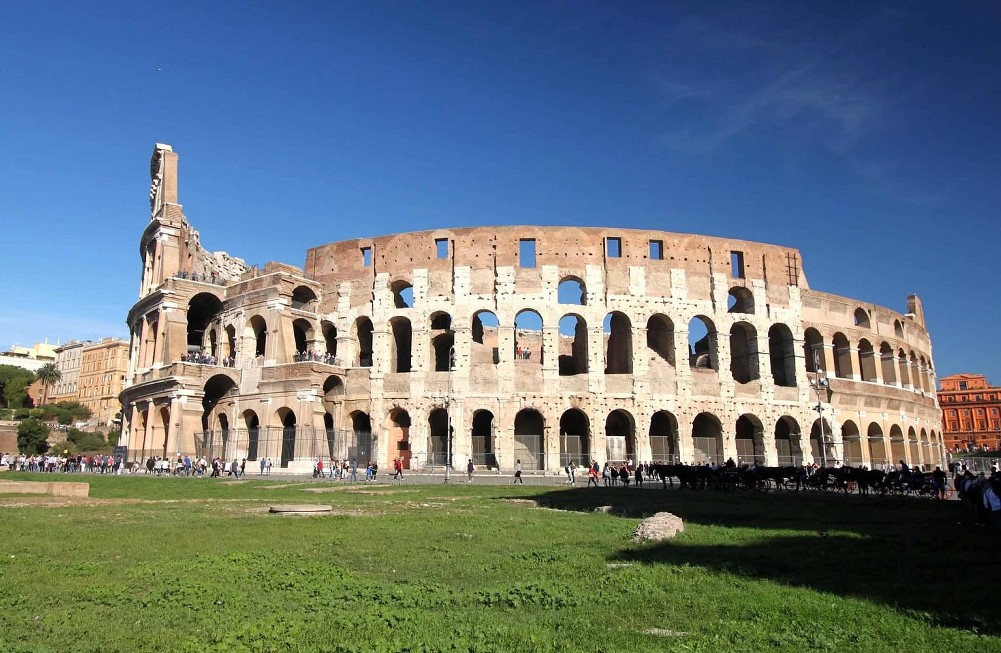 Full outside view of the Roman Colosseum in a field of grass