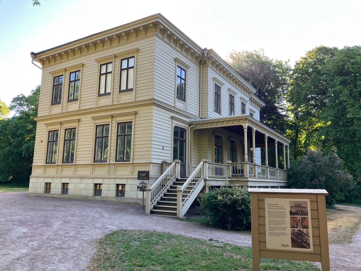 Grand old wooden boarded building, two storeys.