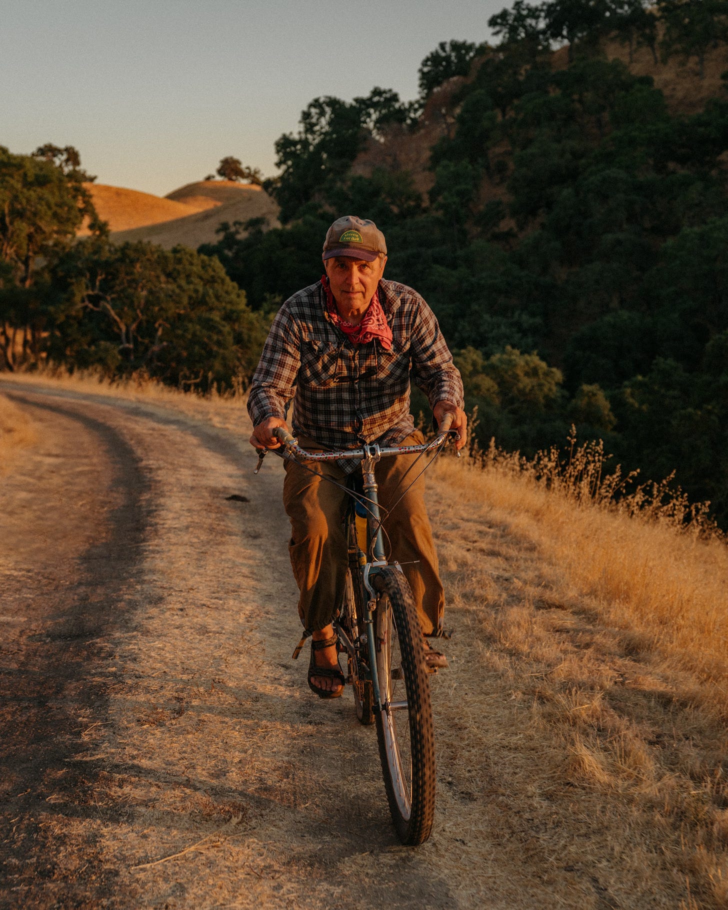 A man rides a bike down a dirt path.