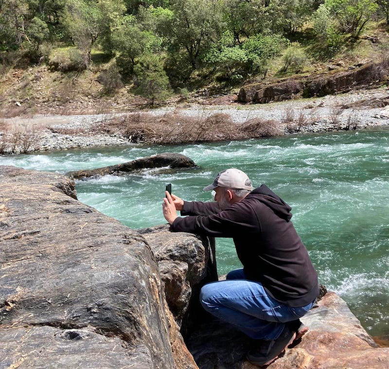 Larry Cornett taking a photo of a river