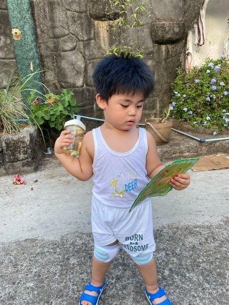 Toddler holding a milk bottle and flash card during his unlimited playtime called Unli Dapa