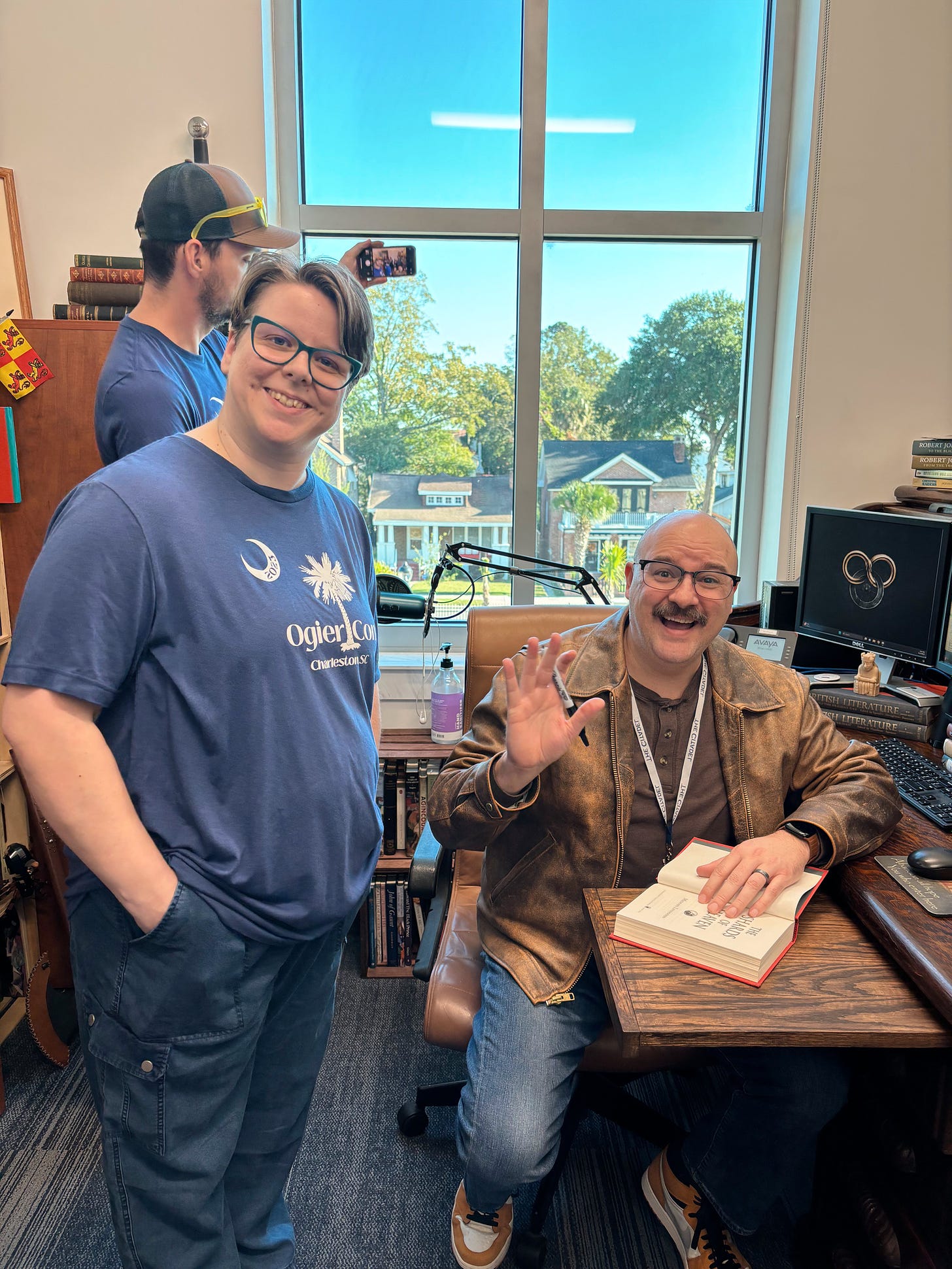 Standing in my Ogier Con shirt next to the distinguished Michael Livingston who is sitting at Robert Jordan’s desk and waving and signing my book