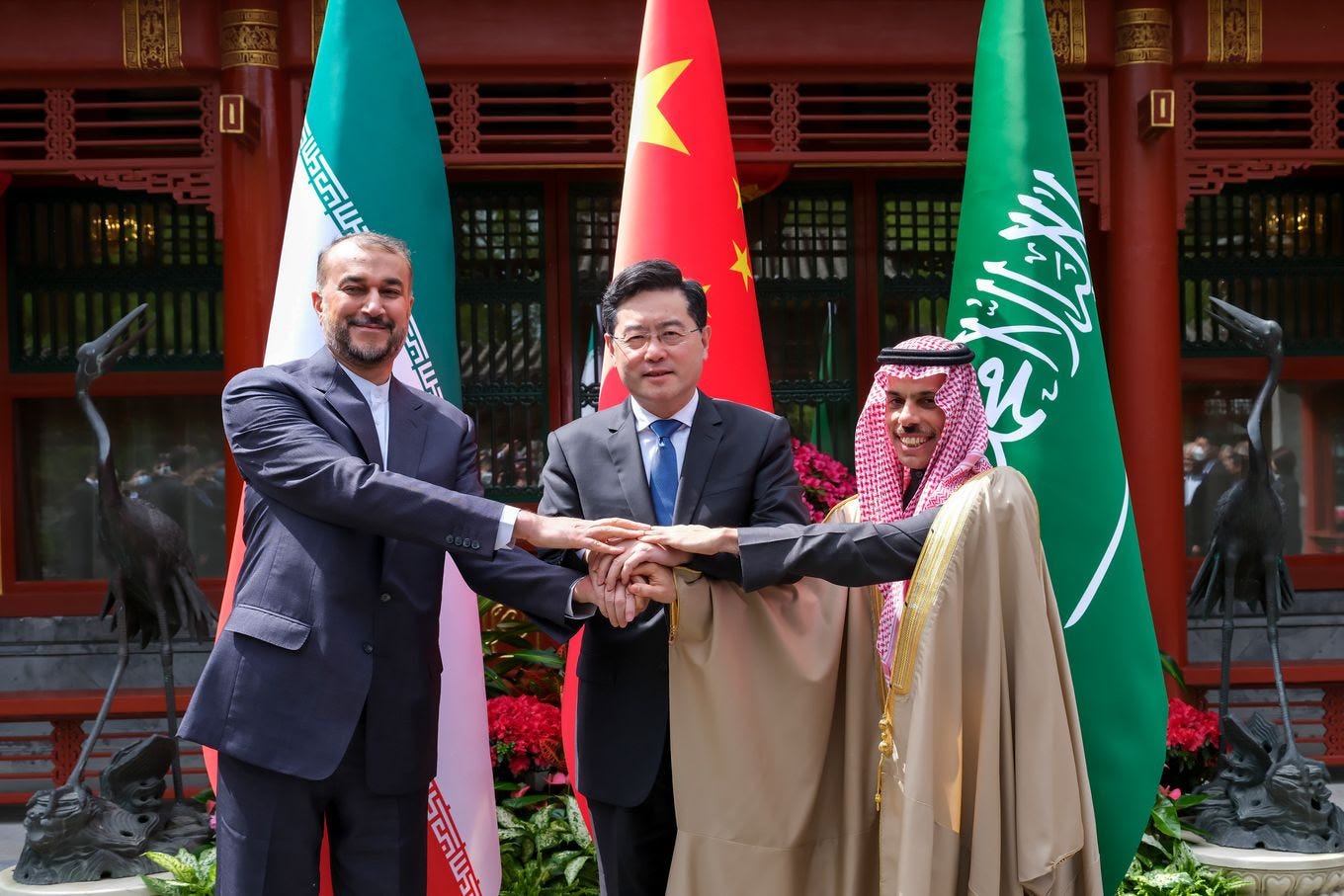 Iranian Foreign Minister Hossein Amirabdollahian holds hands with his Saudi Arabian counterpart, Prince Faisal bin Farhan al-Saud, and Chinese counterpart, Qin Gang, in Beijing on Thursday. (Ding Lin/Xinhua News Agency/AP/AP)