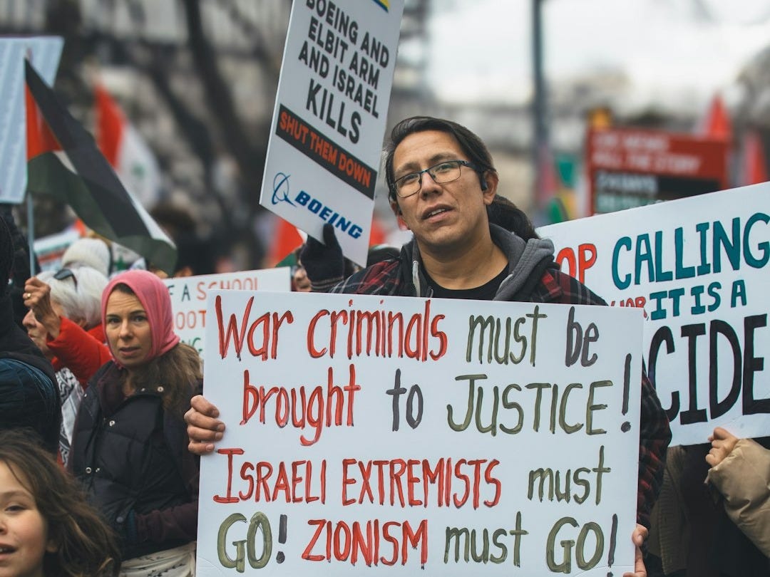 a man holding a sign in front of a crowd of people