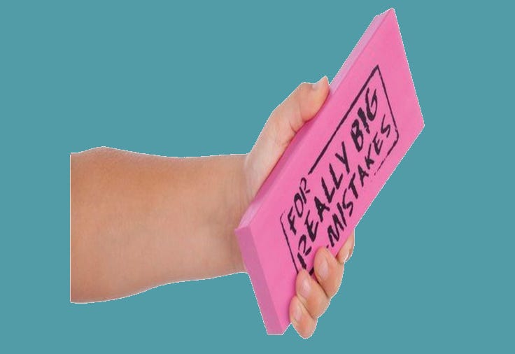 hand holding an eraser that fits into the whole hand. Eraser is pink with the words: for really big mistakes. Background is teal
