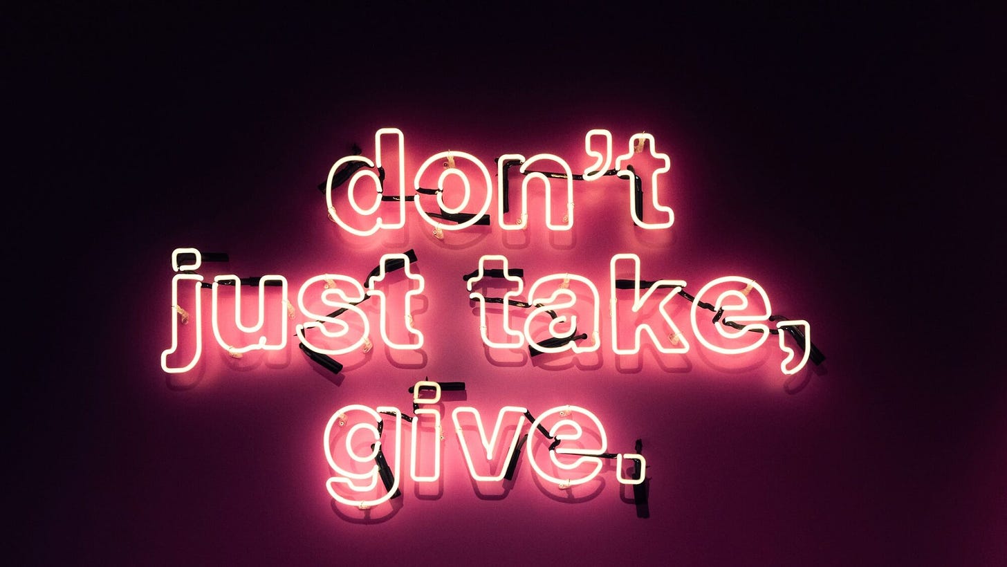 photo of neon pink sign that says "don't just take, give."