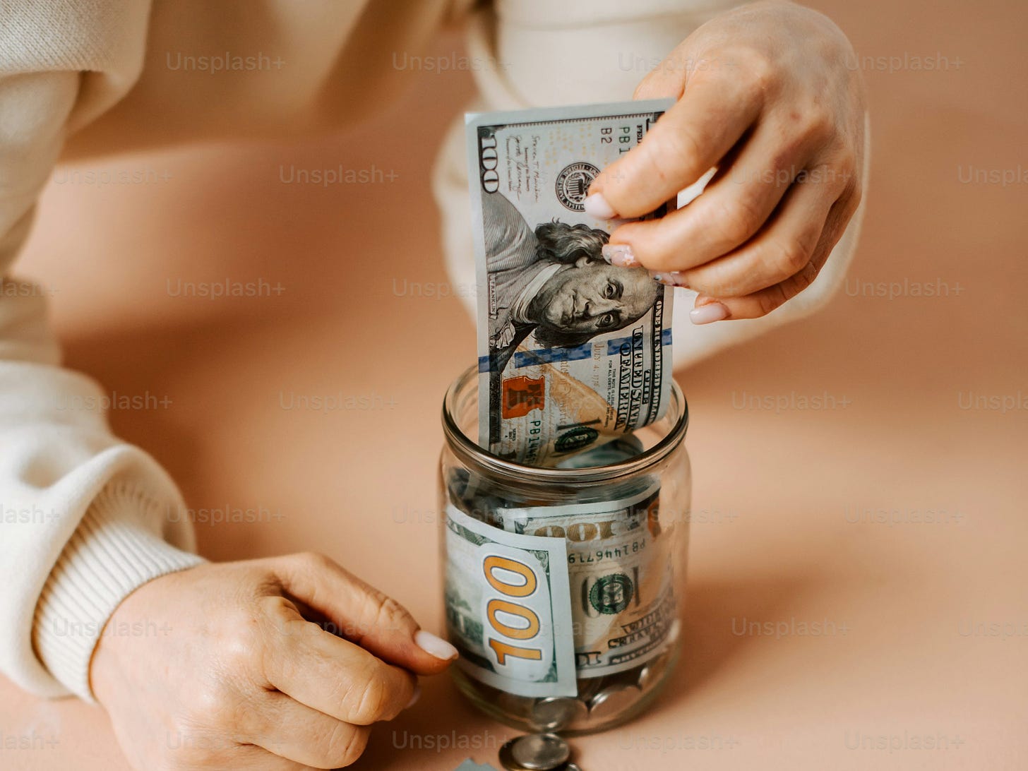 a person putting money into a jar