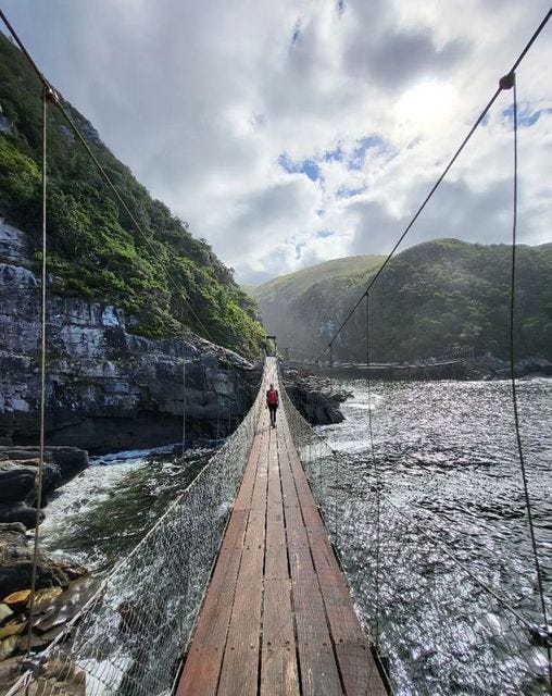 May be an image of 1 person and the Carrick-a-Rede Rope Bridge