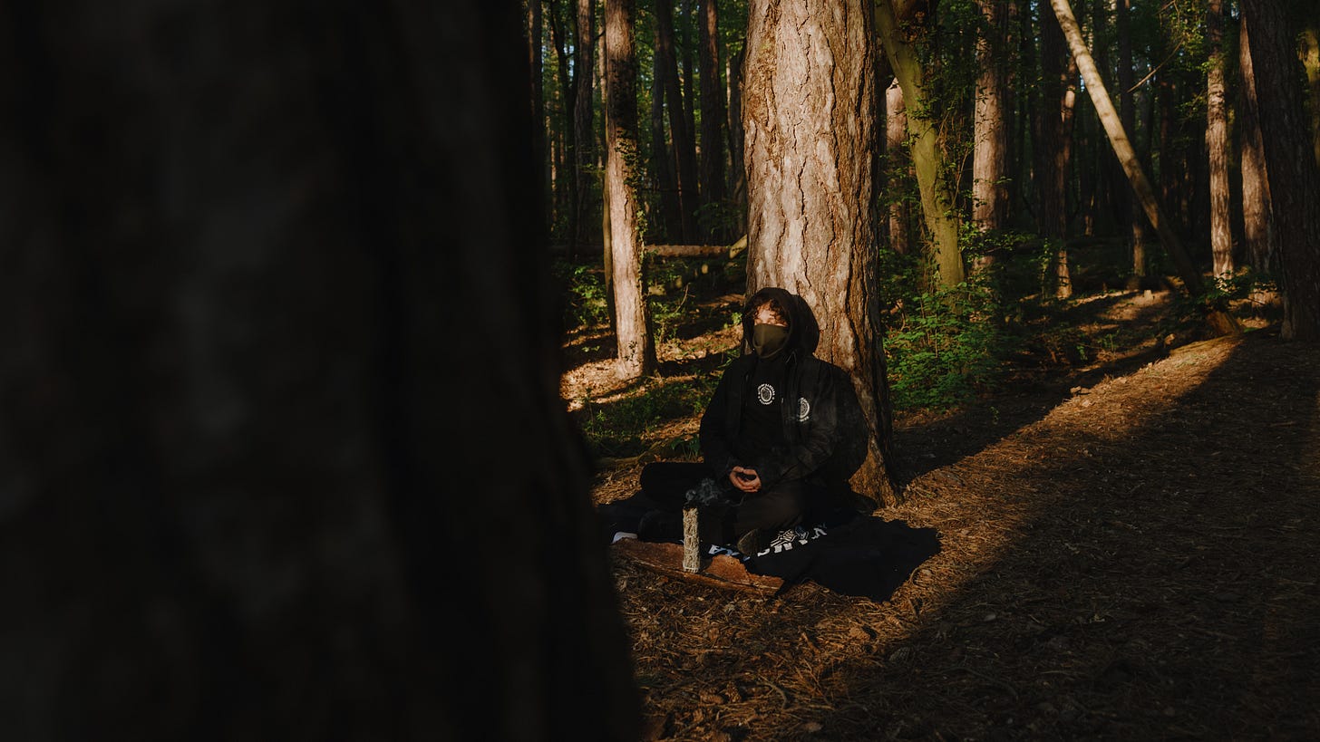 Female runner meditating in the woods