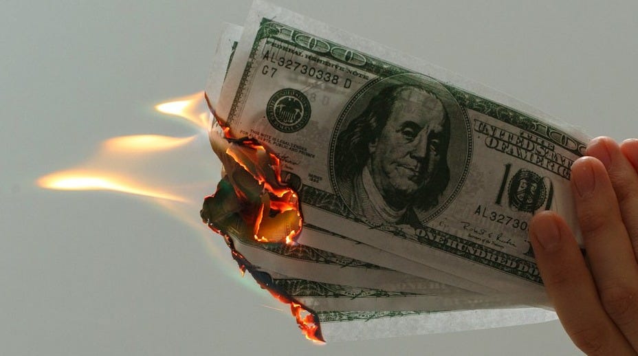 time lapse photography of several burning US dollar banknotes