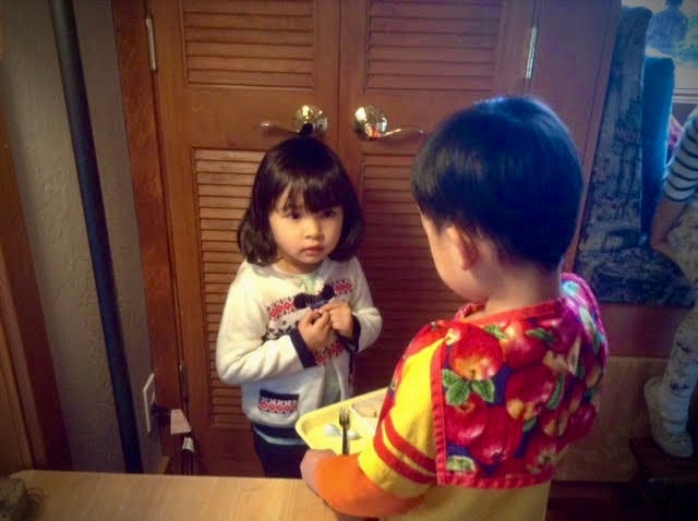 little girl facing little boy holding tray with fork and food