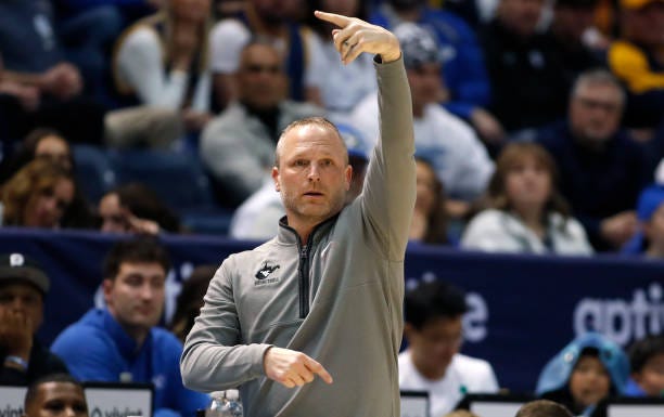 Darian DeVries head coach of the West Virginia Mountaineers calls in a play during the first half of their game against the Brigham Young Cougars at...