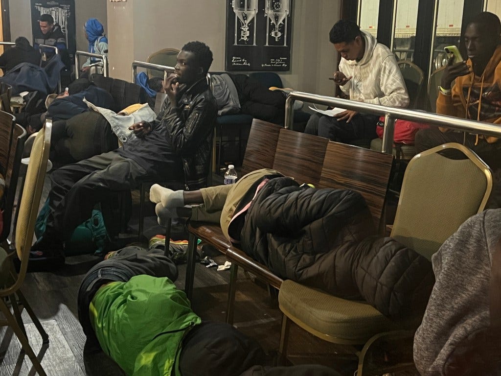 Migrants are seen sleeping on chairs in a lounge in the Roosevelt Hotel in Manhattan on Sep. 26, 2023.