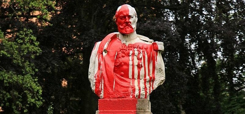 Photo of a statue of a general with red paint thrown over it