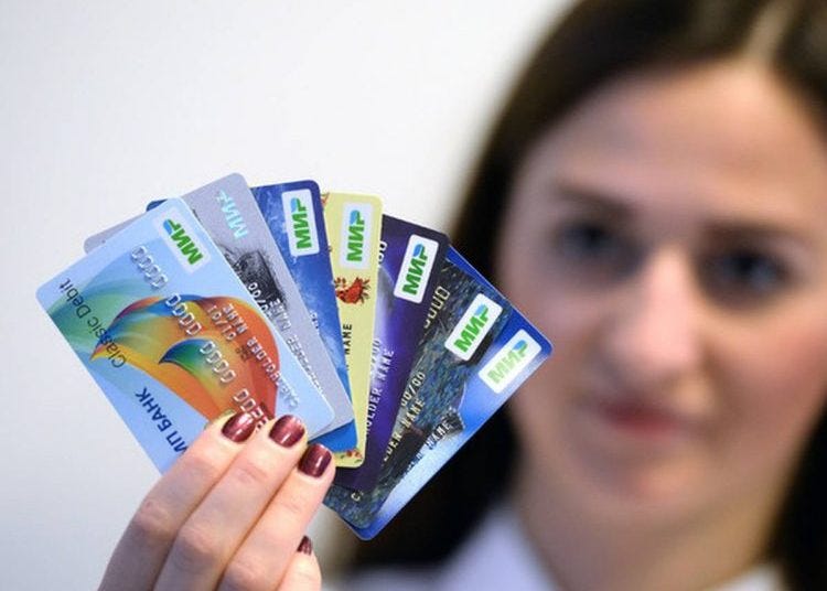 A person holding several credit cards

Description automatically generated