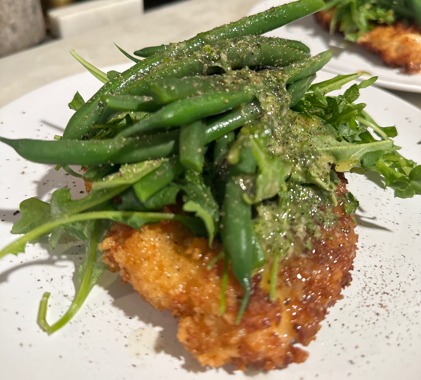 Mastering the Ease of Home Cooking Chicken Schnitzel with Arugula and Green Beans topped with eggless caesar dressing