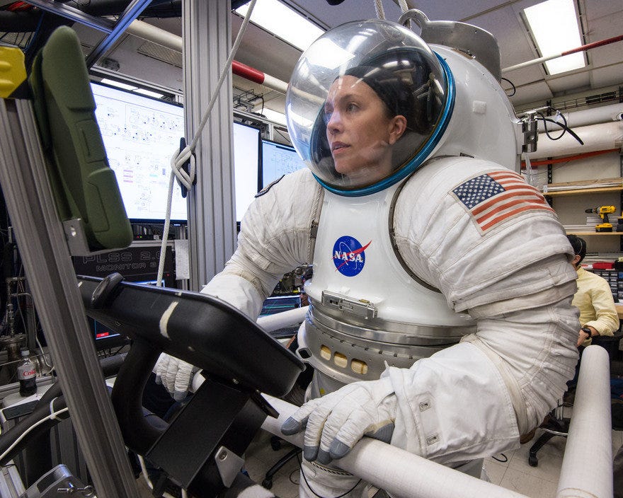 A woman in a spacesuit on a treadmill.