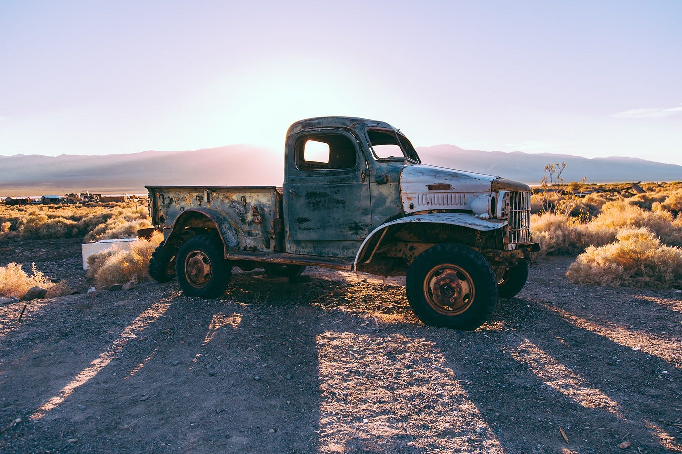 Antique pic up truck against a desert mountain sunset Antique pic up truck against a desert mountain sunset