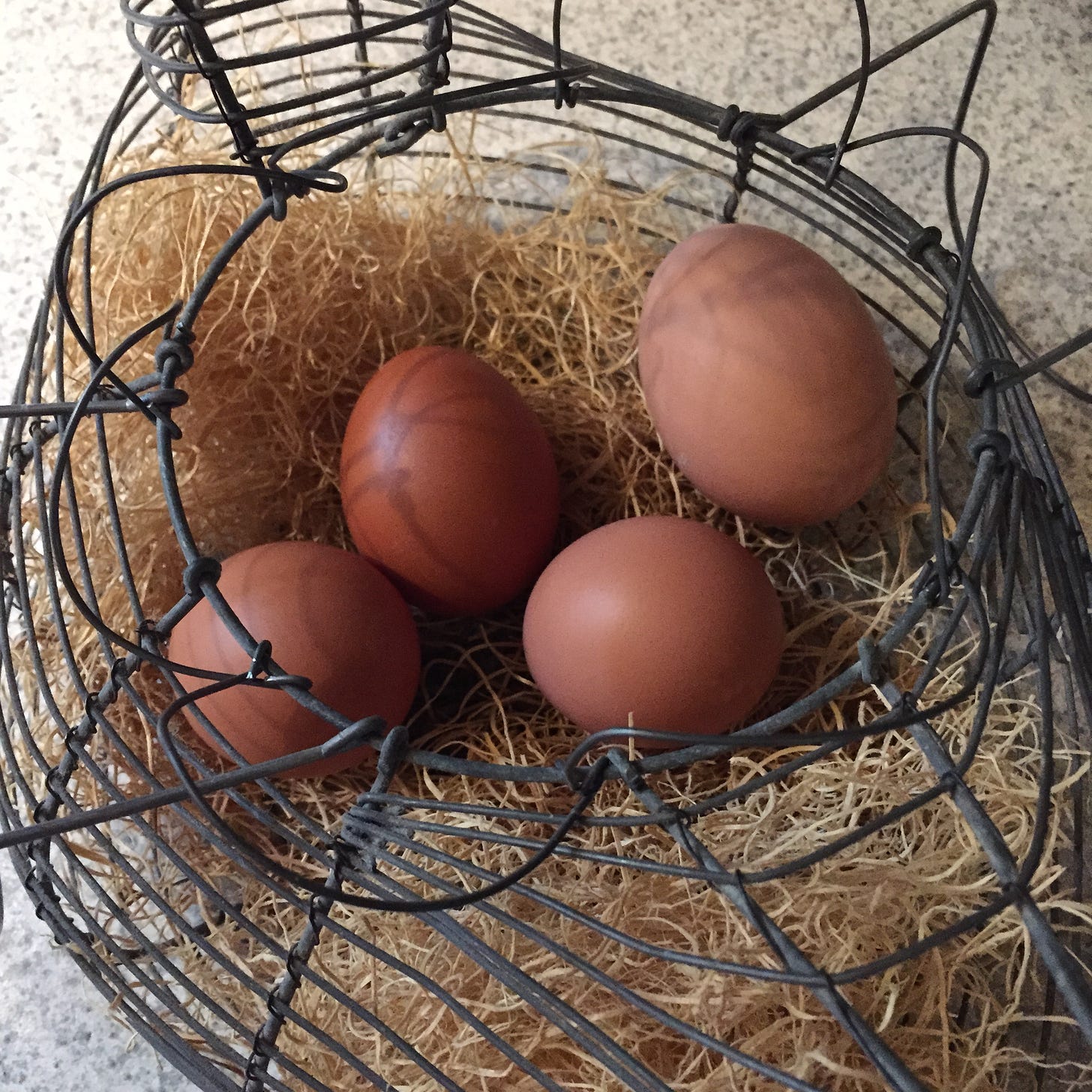 wire basket full of brown eggs