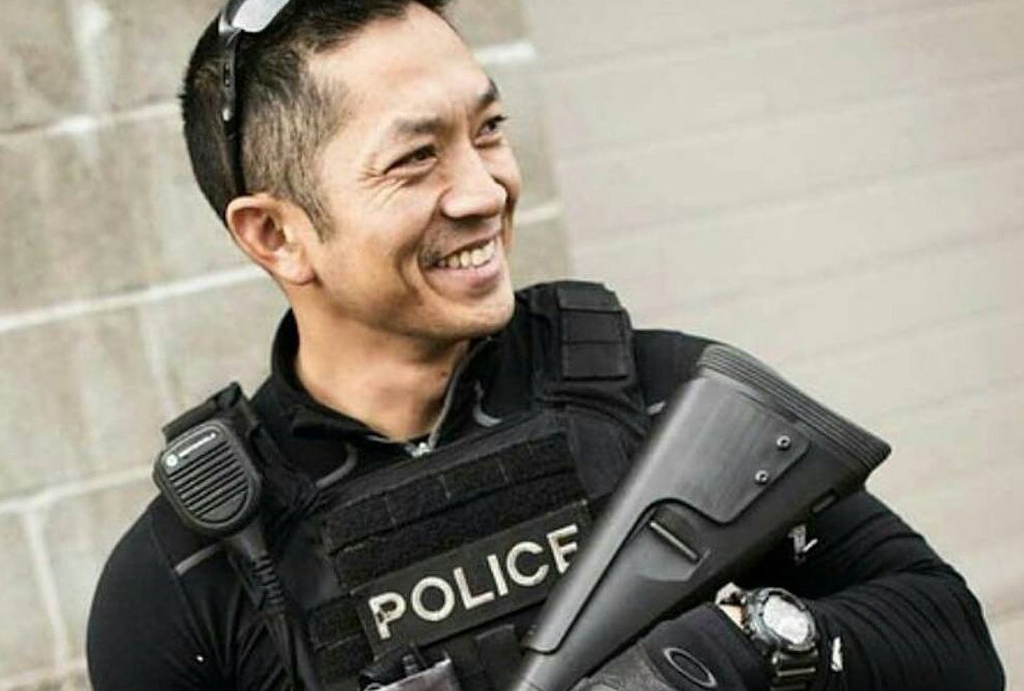In this image on the Instagram page of “Chris Tran” (SPD Ofc. Chris Brownlee), Brownlee smiles like a goon as he holds a shotgun and looks off into the distance. 