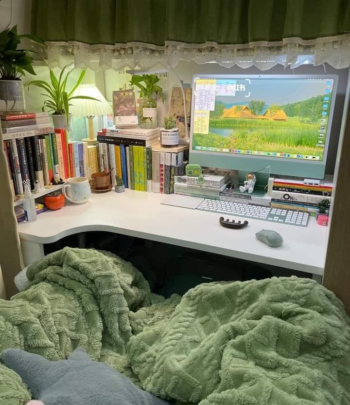 This may contain: a desk with a computer and books on it in front of a book shelf filled with books