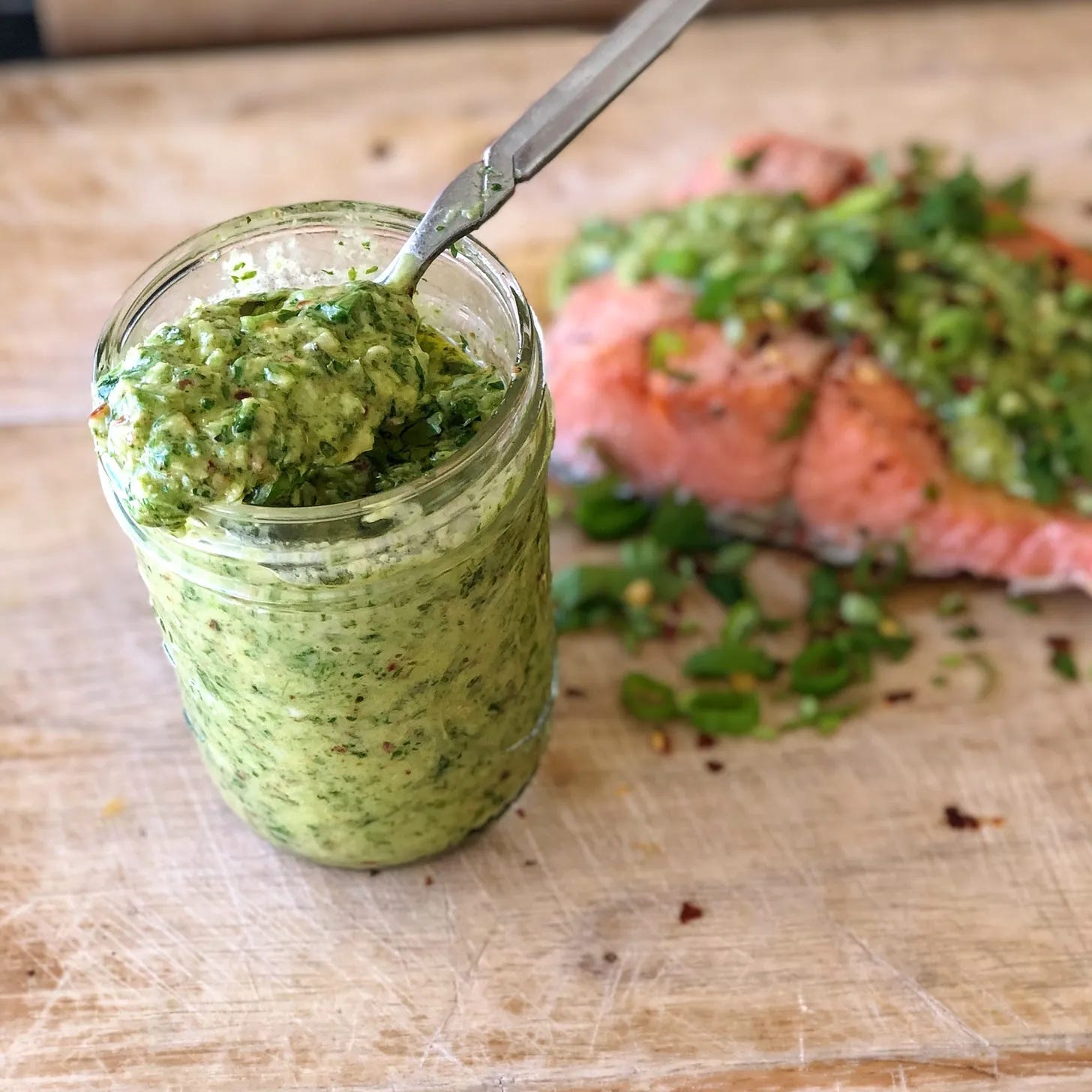 Chimichurri sauce in a glass jar.