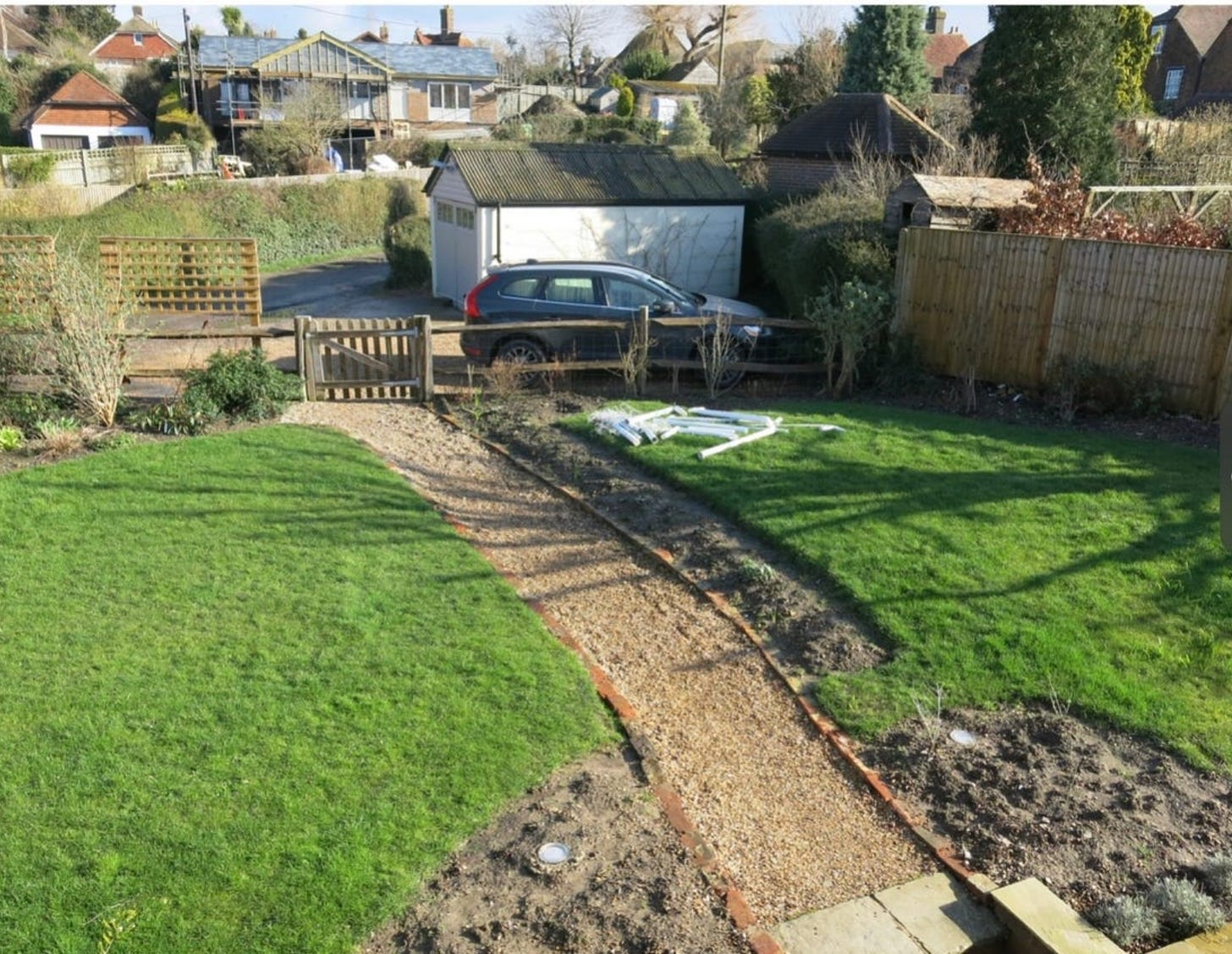 an empty garden with grass and a path and a garage